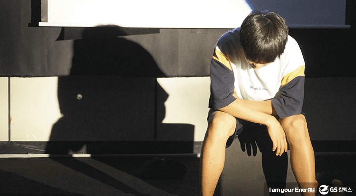 아이 한 명이 무대에 앉아 연극을 하고 있다