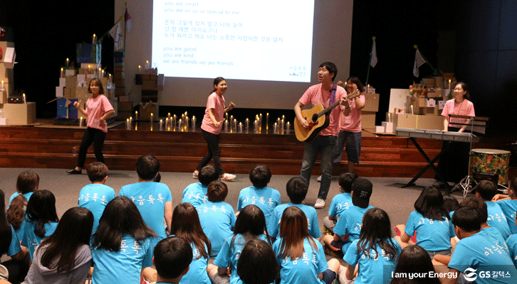 마음톡톡 치유캠프에서 아이들이 강당에 모여 음악과 만들기 등 예술활동에 참여하고 있다