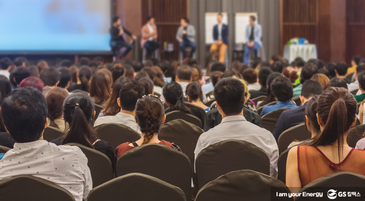 사람들이 강당에서 교육을 받고 있다.