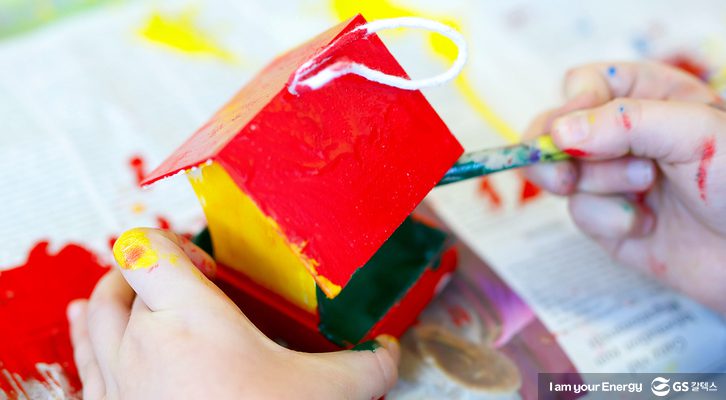 아이가 자기가 만든 집을 꾸미고 있다