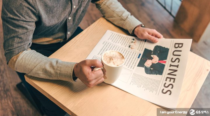"GS칼텍스 2018년 4월 뉴스브리핑 텍스트 디자인 텍스트 디자인 의자에 앉아 왼손에는 신문, 오른손에는 커피를 잡고 있는 모습"