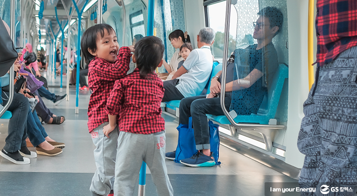 아이들이 공공장소인 지하철에서 예의에 어긋나게 시끄러운 장난을 치고 있다.