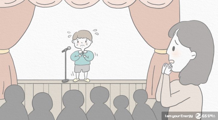 무대공포증을 가진 아동이 발표 상황에서 불안 증상을 보이고 있다