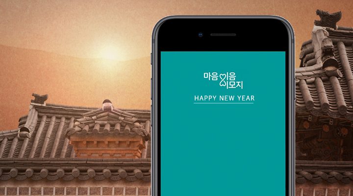 동이 트는 모습을 배경으로 핸드폰에 입력된 마음이음 이모지의 'HAPPY NEW YEAR' 메시지 사진