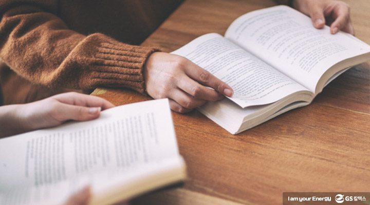 책을 읽고 있는 사람들의 손이 클로즈업 된 모습