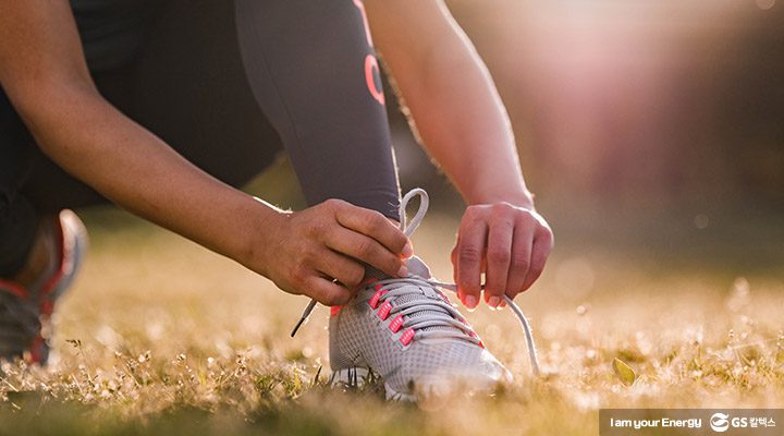 앉아서 신발끈을 묶는 여자의 모습이 클로즈업 된 모습